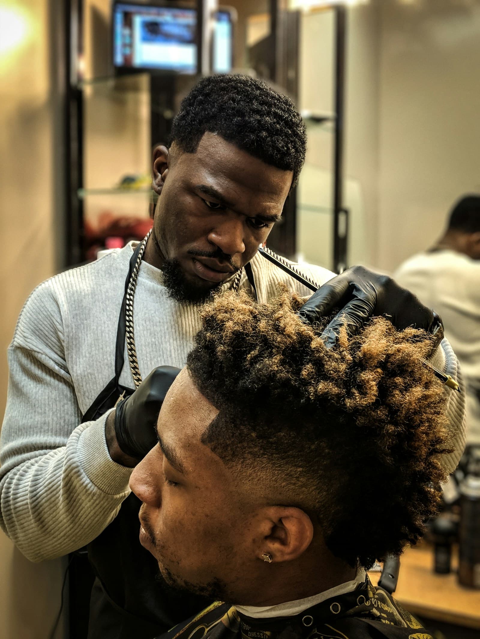 A barber lining up a client's hair with clippers.