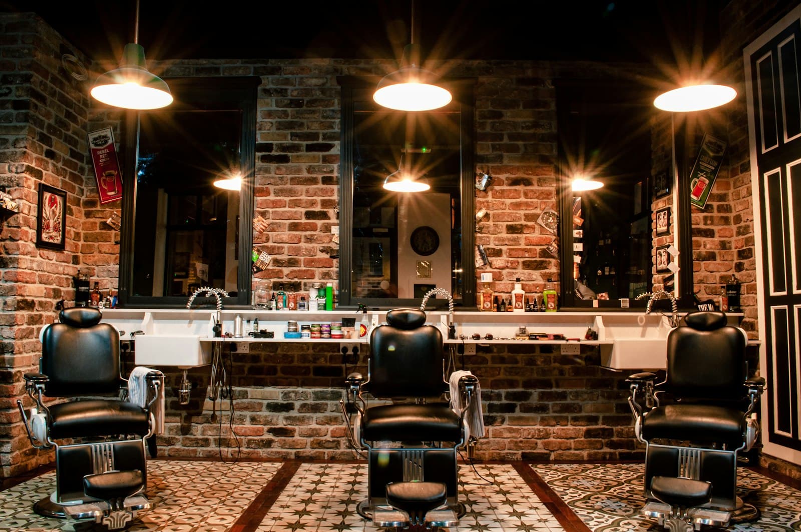 A barbershop floor with three chairs under hanging lamps.