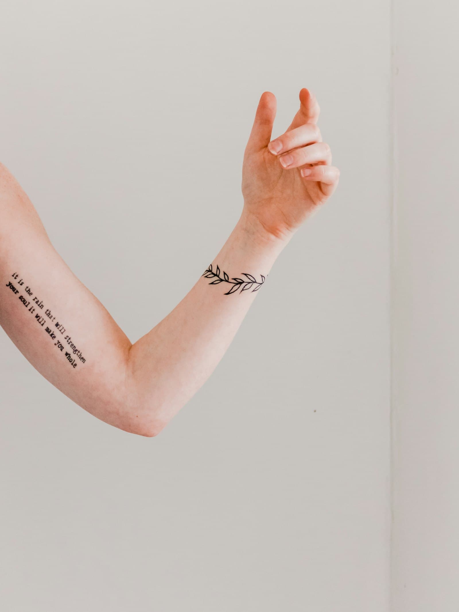 A fine line laurel around a wrist.